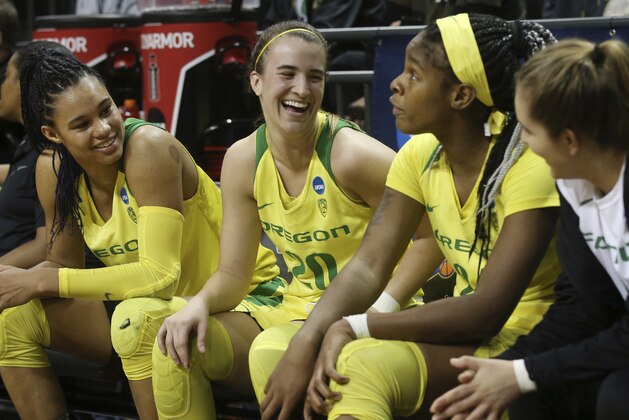 Oregon's Satou Sabally, left, Sabrina Ionescu, Ruthy Hebard and Taylor Chavez smile and talk on the bench near the end of the team's first-round game against Portland State in the NCAA women's college basketball tournament Friday, March 22, 2019, in Eugene, Ore. (AP Photo/Chris Pietsch)