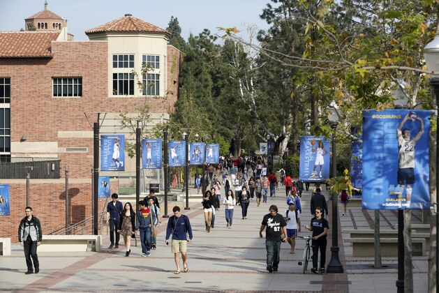 FILE - In this Feb. 26, 2015, file photo, students walk on the University of California, Los Angeles campus. Federal authorities have charged college coaches and others in a sweeping admissions bribery case in federal court. The racketeering conspiracy charges were unsealed Tuesday, March 12, 2019, against coaches at schools including UCLA, Wake Forest, Stanford, Georgetown, and the University of Southern California. (AP Photo/Damian Dovarganes, File)