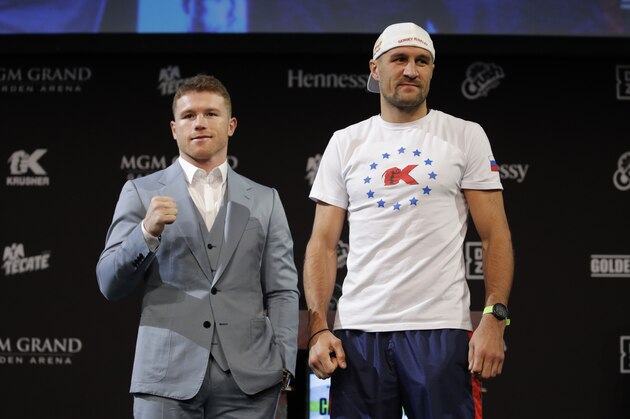 Sergey Kovalev, right, and Canelo Alvarez pose for photographers during a news conference Wednesday, Oct. 30, 2019, in Las Vegas. The two are scheduled to fight in a WBO light heavyweight title bout Saturday in Las Vegas. (AP Photo/John Locher)