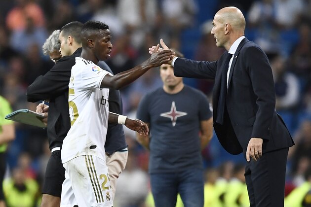 Real Madrid's Brazilian forward Vinicius Junior (L) shakes hands with Real Madrid's French coach Zinedine Zidane as he leaves the pitch during the Spanish league football match between Real Madrid CF and CA Osasuna at the Santiago Bernabeu stadium in Madrid, on September 25, 2019. (Photo by OSCAR DEL POZO / AFP)        (Photo credit should read OSCAR DEL POZO/AFP/Getty Images)