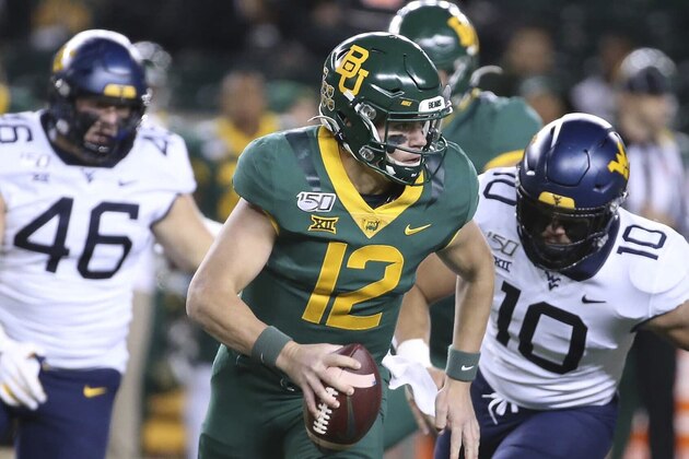 Baylor quarterback Charlie Brewer (12) carries in front of West Virginia linebacker Dylan Tonkery (10) and defensive lineman Reese Donahue (46) during the first half of an NCAA college football game in Waco, Texas, Thursday, Oct. 31, 2019. (AP Photo/Jerry Larson)