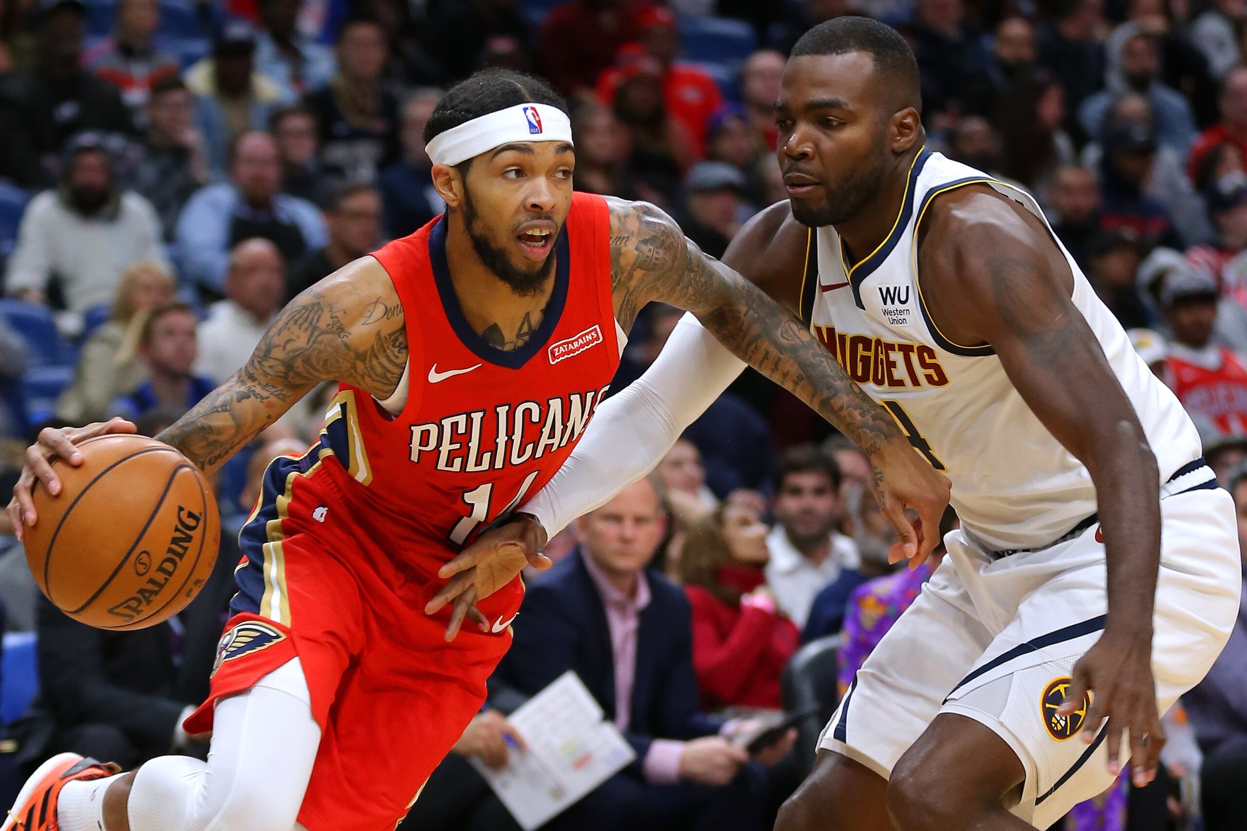 NEW ORLEANS, LOUISIANA - OCTOBER 31: Brandon Ingram #14 of the New Orleans Pelicans drives against Paul Millsap #4 of the Denver Nuggets during the first half of a game at the Smoothie King Center on October 31, 2019 in New Orleans, Louisiana. NOTE TO USER: User expressly acknowledges and agrees that, by downloading and or using this Photograph, user is consenting to the terms and conditions of the Getty Images License Agreement.  (Photo by Jonathan Bachman/Getty Images)
