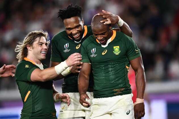 South Africa's scrum-half Faf de Klerk (L) and South Africa's centre Lukhanyo Am (C) congratulate South Africa's wing Makazole Mapimpi after he scored a try during the Japan 2019 Rugby World Cup final match between England and South Africa at the International Stadium Yokohama in Yokohama on November 2, 2019. (Photo by Anne-Christine POUJOULAT / AFP) (Photo by ANNE-CHRISTINE POUJOULAT/AFP via Getty Images)