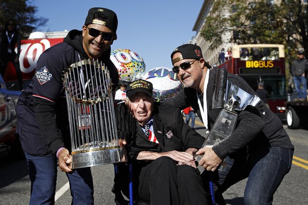 Washington Nationals manager Dave Martinez, left, and general manager Mike Rizzo, right, pose with Sidney Walton, age 100, after showing him the World Series and NLCS trophies before a parade to celebrate the team's World Series baseball championship over the Houston Astros, Saturday, Nov. 2, 2019, in Washington. (AP Photo/Patrick Semansky)