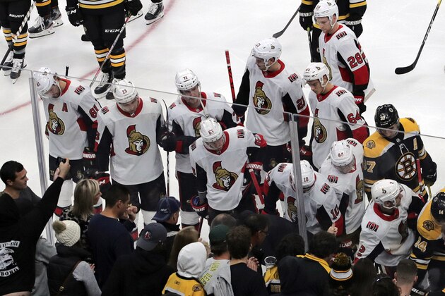 Ottawa Senators and Boston Bruins players gather around Senators right wing Scott Sabourin, who was injured on a play with Boston Bruins right wing David Backes, as he gets taken from the ice on a stretcher during the first period of an NHL hockey game in Boston, Saturday, Nov. 2, 2019. (AP Photo/Charles Krupa)