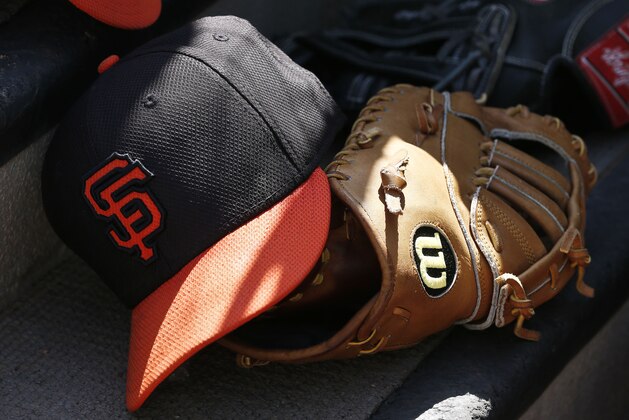 A San Francisco Giants player keeps his hat and glove on the steps out of the dugout during an MLB spring training baseball game against the Colorado Rockies, Friday, March 22, 2013, in Scottsdale, Ariz. (AP Photo/Ross D. Franklin)