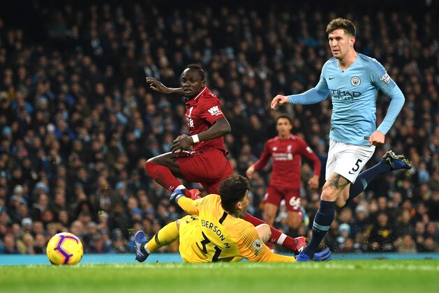 MANCHESTER, ENGLAND - JANUARY 03: Sadio Mane of Liverpool shoots past Ederson of Manchester City as John Stones of Manchester City looks on during the Premier League match between Manchester City and Liverpool FC at the Etihad Stadium on January 3, 2019 in Manchester, United Kingdom.  (Photo by Shaun Botterill/Getty Images)