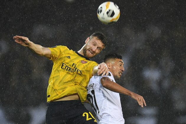 GUIMARAES, PORTUGAL - NOVEMBER 06: Shkodran Mustafi of Arsenal battles for possession with in the air with Davidson of Vitoria Guimaraes  during the UEFA Europa League group F match between Vitoria Guimaraes and Arsenal FC at Estadio Dom Afonso Henriques on November 06, 2019 in Guimaraes, Portugal. (Photo by Octavio Passos/Getty Images)
