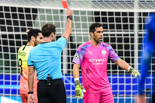 Belarussian referee Aleksei Kulbakov (L) gives a red card to Manchester City's Chilean goalkeeper Claudio Bravo during the UEFA Champions League Group C football match Atalanta Bergamo vs Manchester City on November 6, 2019 at the San Siro stadium in Milan. (Photo by Miguel MEDINA / AFP) (Photo by MIGUEL MEDINA/AFP via Getty Images)