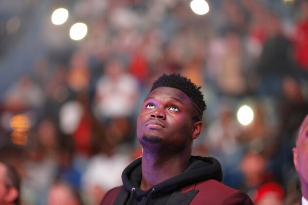 New Orleans Pelicans forward Zion Williamson watches the video screen during a player introduction video before an NBA basketball game in New Orleans, Thursday, Oct. 31, 2019. The rookie first round draft pick is recovering from knee surgery and is expected to return to action sometime in December. (AP Photo/Gerald Herbert)