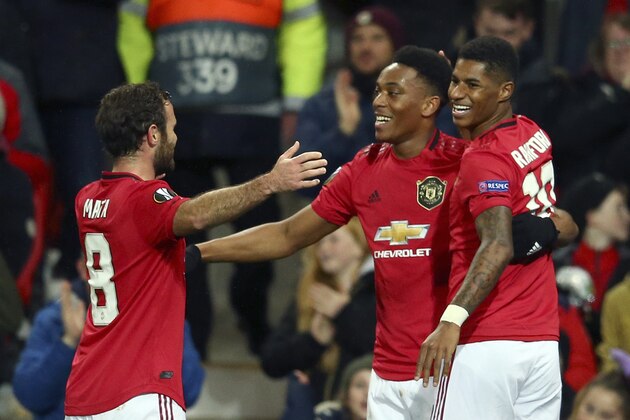 Manchester United's Anthony Martial, center, celebrates with Juan Mata and Marcus Rashford, right, after scoring his side's second goal during the Europa League group L soccer match between Manchester United and FK Partizan at Old Trafford Stadium in Manchester, England, Thursday, Nov. 7, 2019. (AP Photo/Dave Thompson)