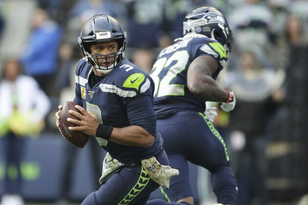 Seattle Seahawks quarterback Russell Wilson drops to make a touchdown pass to Seahawks tight end Jacob Hollister (not shown) during the first half of an NFL football game against the Tampa Bay Buccaneers, Sunday, Nov. 3, 2019, in Seattle. (AP Photo/Scott Eklund)