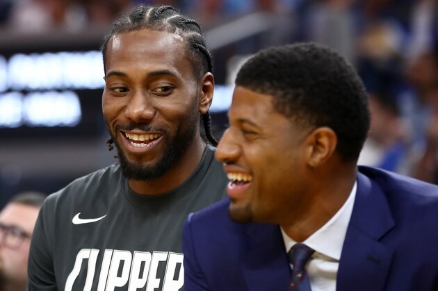 SAN FRANCISCO, CALIFORNIA - OCTOBER 24:   Kawhi Leonard #2 and Paul George #13 of the LA Clippers smile while sitting on the bench during their game against the Golden State Warriors at Chase Center on October 24, 2019 in San Francisco, California.  NOTE TO USER: User expressly acknowledges and agrees that, by downloading and or using this photograph, User is consenting to the terms and conditions of the Getty Images License Agreement. (Photo by Ezra Shaw/Getty Images)