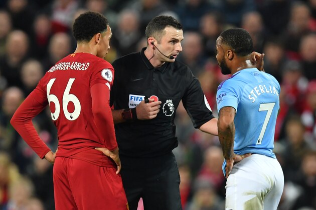 English referee Michael Oliver (C) chats with Manchester City's English midfielder Raheem Sterling (R) and Liverpool's English defender Trent Alexander-Arnold (L) during the English Premier League football match between Liverpool and Manchester City at Anfield in Liverpool, north west England on November 10, 2019. (Photo by Paul ELLIS / AFP) / RESTRICTED TO EDITORIAL USE. No use with unauthorized audio, video, data, fixture lists, club/league logos or 'live' services. Online in-match use limited to 120 images. An additional 40 images may be used in extra time. No video emulation. Social media in-match use limited to 120 images. An additional 40 images may be used in extra time. No use in betting publications, games or single club/league/player publications. /  (Photo by PAUL ELLIS/AFP via Getty Images)