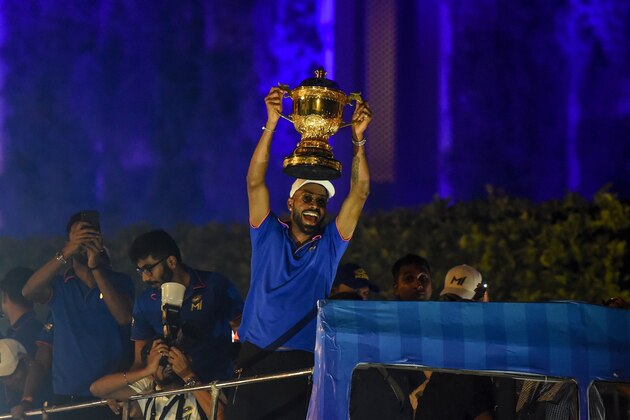 Mumbai Indians cricket player Hardik Pandya (C) holds the winning cup as the team travels in a open bus during a celebration procession after arriving in Mumbai on May 13, 2019. - Mumbai Indians team won the 2019 Indian Premier League (IPL) Twenty20 cricket tournament title. (Photo by PUNIT PARANJPE / AFP)        (Photo credit should read PUNIT PARANJPE/AFP via Getty Images)