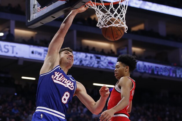 Sacramento Kings guard Bogdan Bogdanovic, left, dunks next to Portland Trail Blazers guard Anfernee Simons during the first quarter of an NBA basketball game in Sacramento, Calif., Tuesday, Nov. 12, 2019.(AP Photo/Rich Pedroncelli)