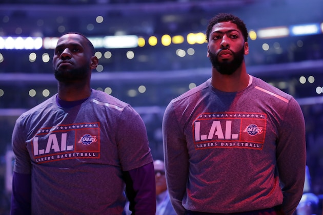 Los Angeles Lakers' LeBron James, left, and Anthony Davis listen to the national anthem before an NBA basketball game against the Toronto Raptors Sunday, Nov. 10, 2019, in Los Angeles. (AP Photo/Marcio Jose Sanchez)
