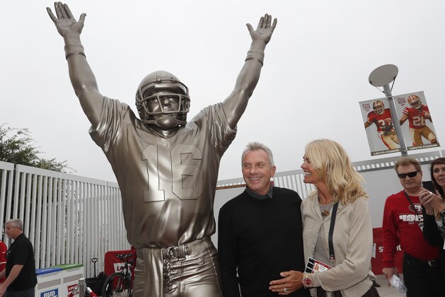 Former San Francisco 49ers quarterback Joe Montana, center, and his wife Jennifer pose for photos next to a statue of Montana commemorating