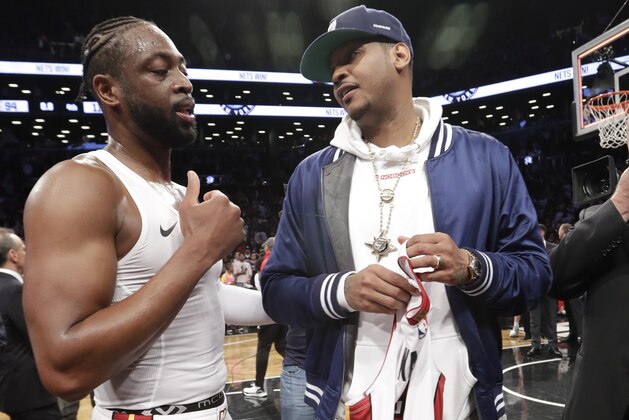Miami Heat guard Dwyane Wade, left, chats with former NBA player Carmelo Anthony, after giving Anthony his game jersey following an NBA basketball game between the Heat and the Brooklyn Nets on Wednesday, April 10, 2019, in New York. It was the last game of Wade's NBA career. (AP Photo/Kathy Willens)
