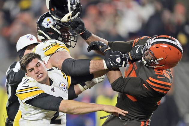 Cleveland Browns defensive end Myles Garrett (95) hits Pittsburgh Steelers quarterback Mason Rudolph (2) with a helmet during the second half of an NFL football game Thursday, Nov. 14, 2019, in Cleveland. (AP Photo/David Richard)