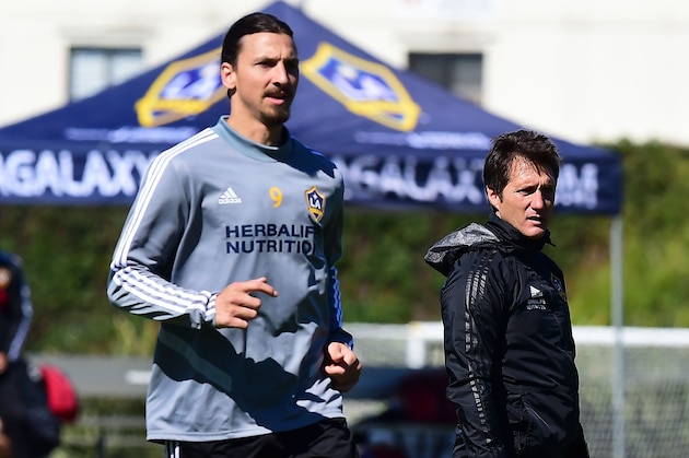 Guillermo Barros Schelotto, head coach of the LA Galaxy of the MLS, watches his players during a training session as Galaxy forward Zlatan Ibrahimovic runs past on February 22, 2019 in Carson, California. - From Buenos Aires to Los Angeles, without stops. From Boca to Galaxy, without safety net. Losing the final of the Libertadores against his archrival River to try to resurrect the most honored franchise in MLS history, Guillermo Barros Schelotto has never been afraid of the challenges. (Photo by Frederic J. BROWN / AFP) (Photo credit should read FREDERIC J. BROWN/AFP via Getty Images) Guillermo Barros Schelotto, head coach of the LA Galaxy of the MLS, watches his players during a training session as Galaxy forward Zlatan Ibrahimovic runs past on February 22, 2019 in Carson, California. - From Buenos Aires to Los Angeles, without stops. From Boca to Galaxy, without safety net. Losing the final of the Libertadores against his archrival River to try to resurrect the most honored franchise in MLS history, Guillermo Barros Schelotto has never been afraid of the challenges. (Photo by Frederic J. BROWN / AFP) (Photo credit should read FREDERIC J. BROWN/AFP via Getty Images)