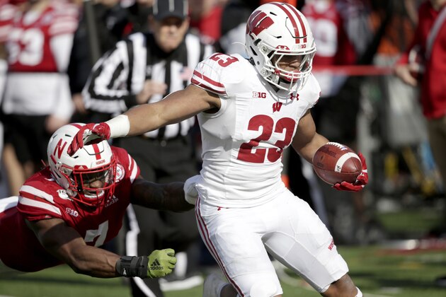 Wisconsin running back Jonathan Taylor (23) carries the ball away from Nebraska linebacker Mohamed Barry, left, during the first half of an NCAA college football game in Lincoln, Neb., Saturday, Nov. 16, 2019. (AP Photo/Nati Harnik)
