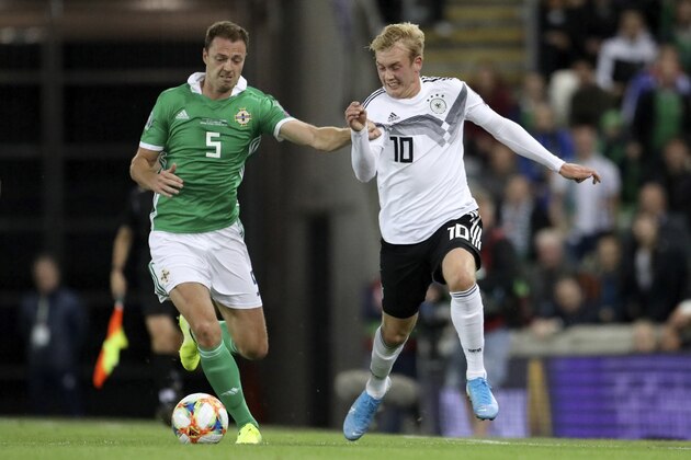 Germany's Julian Brandt vies for the ball with Northern Ireland's Jonny Evans, left, during the Euro 2020 group C qualifying soccer match between Northern Ireland and Germany at Windsor Park, Belfast, Northern Ireland, Monday, Sept. 9, 2019. (AP Photo/Peter Morrison)