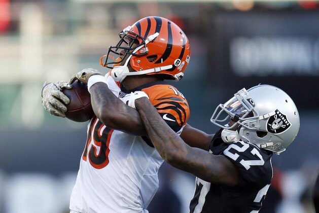 Cincinnati Bengals wide receiver Auden Tate is stopped with the ball by Oakland Raiders cornerback Trayvon Mullen (27) during the second half of an NFL football game in Oakland, Calif., Sunday, Nov. 17, 2019. (AP Photo/D. Ross Cameron)