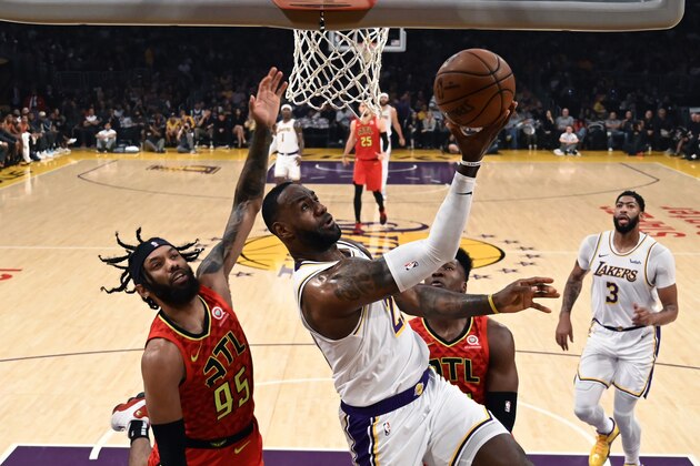 Los Angeles Lakers' LeBron James (23) shoots under pressure from Atlanta Hawks' DeAndre' Bembry during the first half of an NBA basketball game, Sunday, Nov. 17, 2019, in Los Angeles. (AP Photo/Ringo H.W. Chiu)