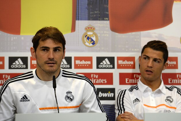 Real Madrid's Portuguese forward Cristiano Ronaldo (R) listens to Spanish goalkeeper Iker Casillas as they give a press conference with their teammates to give their thoughts on 2014 World Cup draw, at the Valdebebas training ground in Madrid on December 8, 2013. World governing body FIFA on December 6 conducted the draw for next year's World Cup, when 32 national teams will converge on Brazil to compete for the sport's most important prize.   AFP PHOTO/ GERARD JULIEN        (Photo credit should read GERARD JULIEN/AFP via Getty Images)