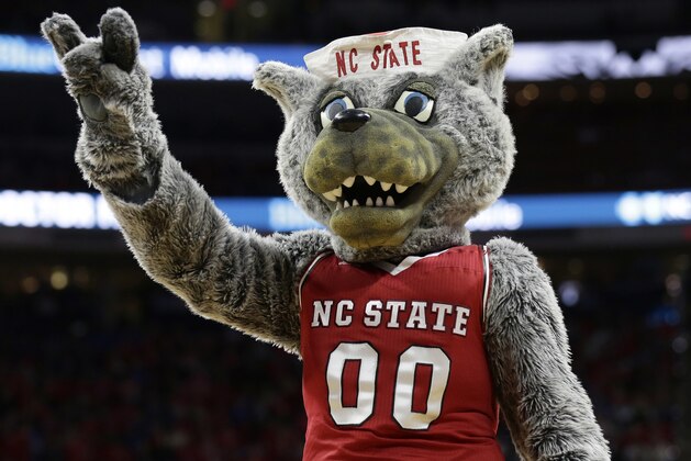 FILE - In this Jan. 6, 2018 file photo, North Carolina State's mascot, Mr. Wuf, gestures to fans during the first half of an NCAA college basketball game against Duke in Raleigh, N.C. Armed with a trademark of school's Wolfpack nickname, the university has forced at least two other schools to stop using it, including Loyola University New Orleans and New York's Keuka College. (AP Photo/Gerry Broome, File)
