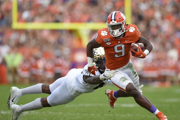 Clemson's Travis Etienne shakes off the tackle attempt by Wake Forest's Ja'Corey Johns during the first half of an NCAA college football game Saturday, Nov. 16, 2019, in Clemson, S.C. (AP Photo/Richard Shiro)