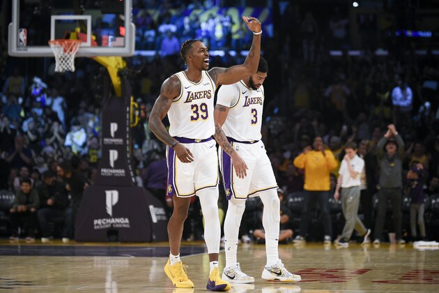 Los Angeles Lakers center Dwight Howard, left, celebrates during the first half of an NBA basketball game as Anthony Davis looks on against the Charlotte Hornets in Los Angeles, Sunday, Oct. 27, 2019. (AP Photo/Kelvin Kuo)