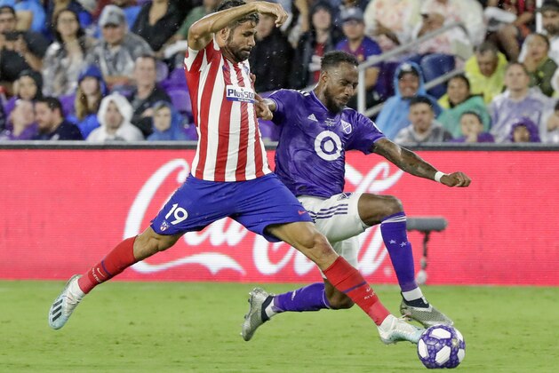Atletico Madrid forward Diego Costa (19) pushes the ball past Minnesota United defender Romain Metanire during the second half of the MLS All-Star soccer match Wednesday, July 31, 2019, in Orlando, Fla. (AP Photo/John Raoux)