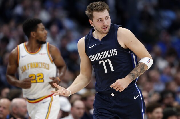 Dallas Mavericks forward Luka Doncic (77) celebrates sinking a 3-point basket as Golden State Warriors forward Glenn Robinson III (22) follows behind in the first half of an NBA basketball game in Dallas, Wednesday, Nov. 20, 2019. (AP Photo/Tony Gutierrez)