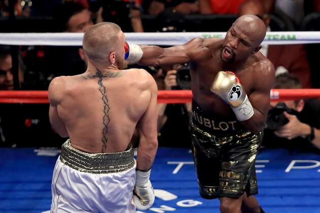 LAS VEGAS, NV - AUGUST 26:  (R-L) Floyd Mayweather Jr. throws a punch at Conor McGregor during their super welterweight boxing match on August 26, 2017 at T-Mobile Arena in Las Vegas, Nevada.  (Photo by Sean M. Haffey/Getty Images)