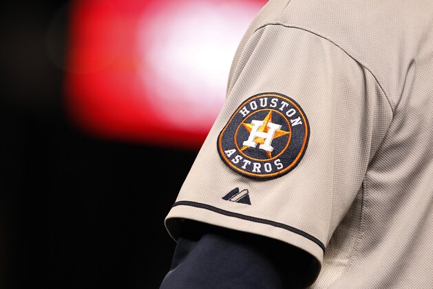 Houston Astros logo shines off sleeve of first base coach Dave Clark in the ninth inning of Astros' 6-3 victory over the Colorado Rockies in a baseball game in Denver on Wednesday, May 29, 2013. (AP Photo/David Zalubowski)