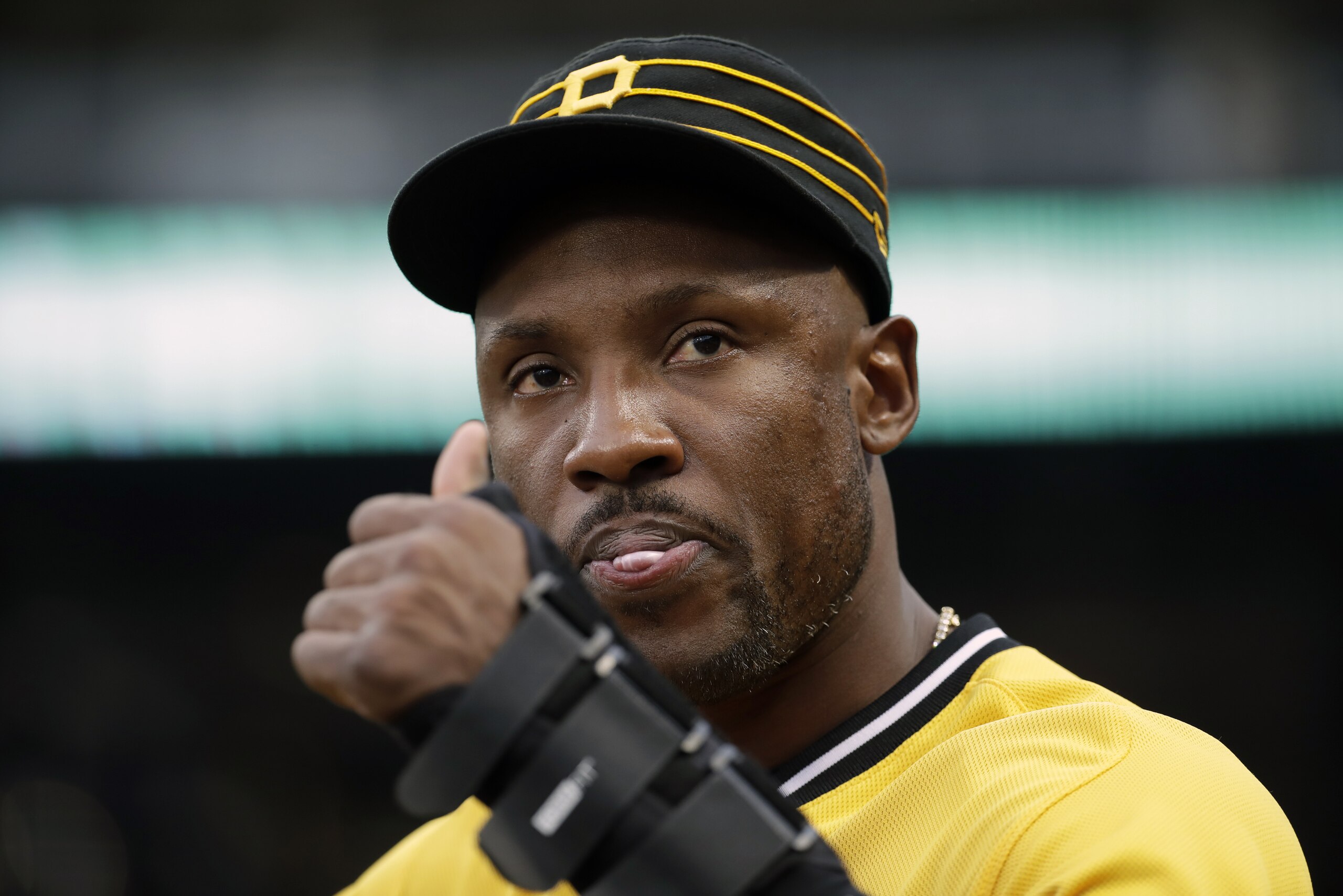 Pittsburgh Pirates' Starling Marte signals to a fan from the dugout during a baseball game against the Cincinnati Reds in Pittsburgh, Sunday, Sept. 29, 2019. Marte did not play in the game. The Reds won 3-1. (AP Photo/Gene J. Puskar)