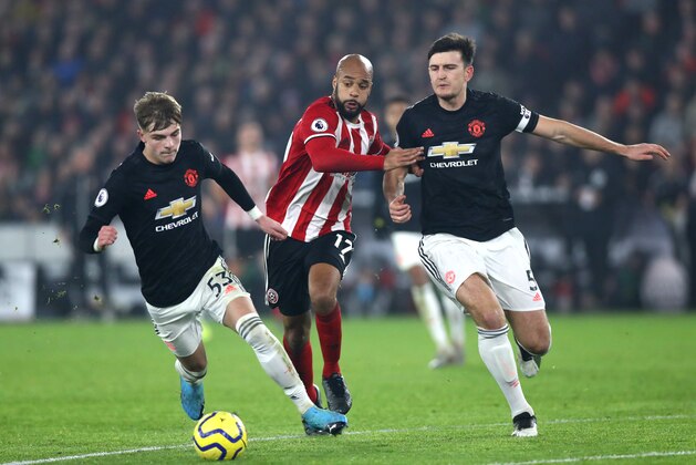 SHEFFIELD, ENGLAND - NOVEMBER 24: Brandon Williams and Harry Maguire of Manchester United  and David McGoldrick of Sheffield United in action  during the Premier League match between Sheffield United and Manchester United at Bramall Lane on November 24, 2019 in Sheffield, United Kingdom. (Photo by Chloe Knott - Danehouse/Getty Images)