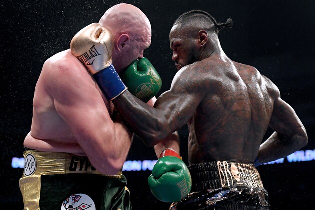 LOS ANGELES, CA - DECEMBER 01:  Deontay Wilder and Tyson Fury punch each other in the ninth round fighting to a draw during the WBC Heavyweight Championship at Staples Center on December 1, 2018 in Los Angeles, California.  (Photo by Harry How/Getty Images)