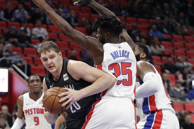Brooklyn Nets center Timofey Mozgov (20) looks to pass around the defense of Detroit Pistons forward Reggie Bullock (25) during the first half of an NBA basketball game, Wednesday, Feb. 7, 2018, in Detroit. (AP Photo/Carlos Osorio)
