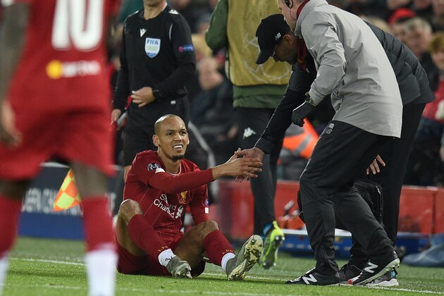 Liverpool's Brazilian midfielder Fabinho (C) is greeted by Liverpool's German manager Jurgen Klopp as he prepares to leave the pitch injured during the UEFA Champions league Group E football match between Liverpool and Napoli at Anfield in Liverpool, north west England on November 27, 2019. (Photo by Oli SCARFF / AFP) (Photo by OLI SCARFF/AFP via Getty Images)