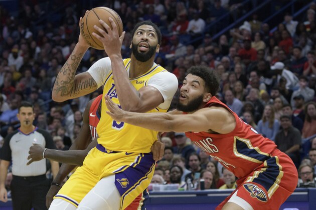 Los Angeles Lakers forward Anthony Davis (3) moves around New Orleans Pelicans guard Kenrich Williams (34) during the first half of an NBA basketball game in New Orleans, Wednesday, Nov. 27, 2019. (AP Photo/Matthew Hinton)