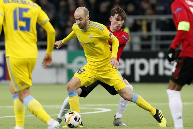 Astana's Ivan Mayewski, centre left, and Manchester United's James Garner challenge for the ball during the Europa League Group L soccer match between Astana and Manchester United in Astana, Kazakhstan, Thursday, Nov. 28, 2019. (AP Photo/Stas Filippov)