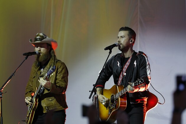 John Osborne, left, and T.J. Osborne of the Brothers Osborne musical duo perform during halftime of an NFL football game between the Detroit Lions and the Chicago Bears, Thursday, Nov. 28, 2019, in Detroit. (AP Photo/Paul Sancya)