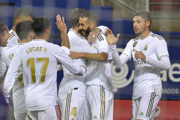 Real Madrid's players congratulate Karim Benzema, second right, after he scored his side's opening goal during the Spanish La Liga soccer match between Eibar and Real Madrid at Ipurua stadium, in Eibar, northern Spain, Saturday, Nov. 9, 2019. (AP Photo/Alvaro Barrientos)