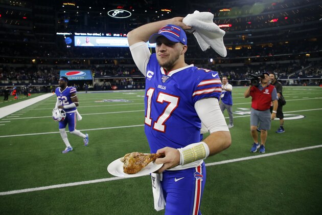 Buffalo Bills' Josh Allen waves a towel motivating fans as he walks off the field with a turkey leg that was presented to him during a post game broadcast interview following their NFL football game against the Dallas Cowboys in Arlington, Texas, Thursday, Nov. 28, 2019. (AP Photo/Michael Ainsworth)