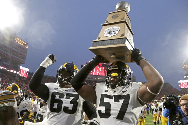 Iowa defensive end Chauncey Golston (57), with offensive lineman Justin Britt (63), carries the Heroes Game Trophy following an NCAA college football game against Nebraska in Lincoln, Neb., Friday, Nov. 29, 2019. Iowa won 27-24. (AP Photo/Nati Harnik)