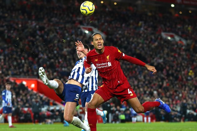 LIVERPOOL, ENGLAND - NOVEMBER 30: Lewis Dunk of Brighton and Hove Albion clears a shot at goal from Virgil Van Dijk of Liverpool during the Premier League match between Liverpool FC and Brighton & Hove Albion at Anfield on November 30, 2019 in Liverpool, United Kingdom. (Photo by Chloe Knott - Danehouse/Getty Images)