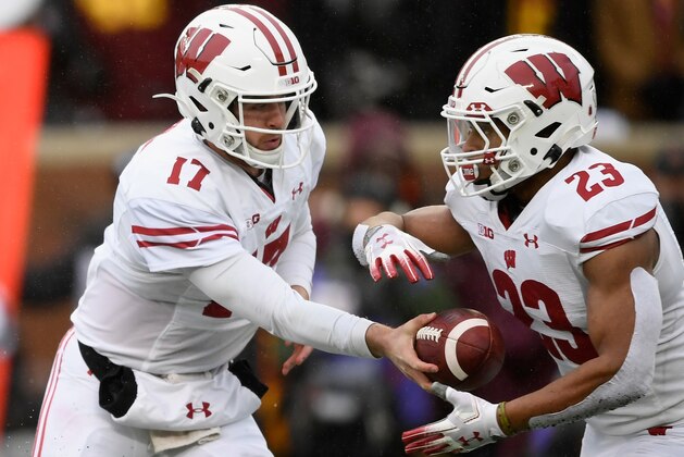 MINNEAPOLIS, MINNESOTA - NOVEMBER 30: Jack Coan #17 of the Wisconsin Badgers hands the ball to teammate Jonathan Taylor #23 against the Minnesota Golden Gophers during the first quarter of the game at TCF Bank Stadium on November 30, 2019 in Minneapolis, Minnesota. (Photo by Hannah Foslien/Getty Images)
